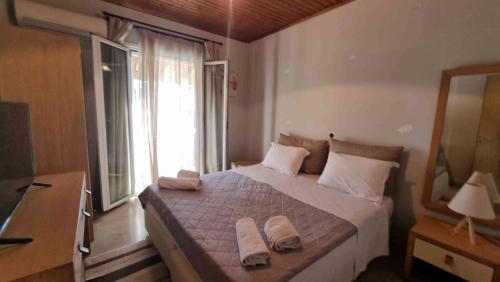 a bedroom with a large bed with two towels on it at Teta's Holiday Home in Melíkia
