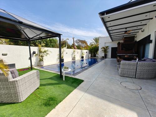 a patio with chairs and a swimming pool at Royal Water Villa in Kiryat Ekron