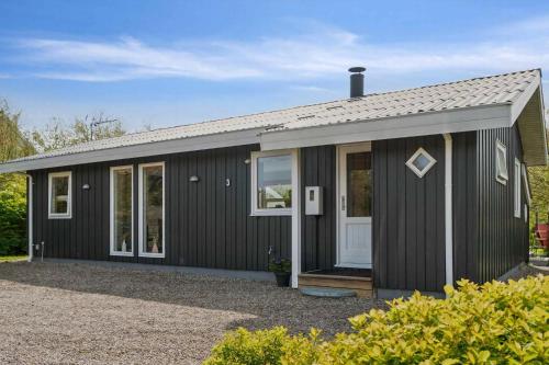 una casa negra con techo gris en Cottage In Scenic Natural Surroundings, en Vordingborg