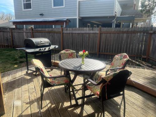 a patio table with chairs and a grill on a deck at Western Cabin in Corvallis