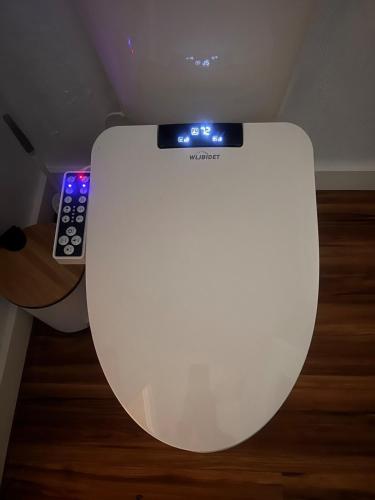 a white toilet with a remote control on top of it at Western Cabin in Corvallis