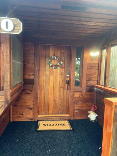 a front door of a wooden cabin with a wreath on it at Western Cabin in Corvallis