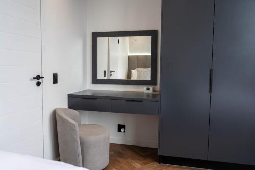 a bedroom with a mirror and a chair at Prada Penthouse at On Park Century City in Cape Town