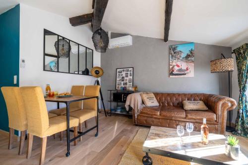a living room with a leather couch and a table at Sun dreams, centre ville historique, 10 minutes de Cannes in Vallauris