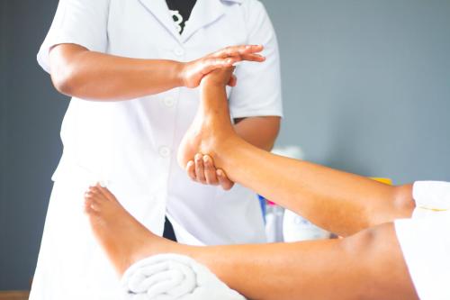 a doctor is holding the legs of a patient at Nefaland Hotel in Dar es Salaam