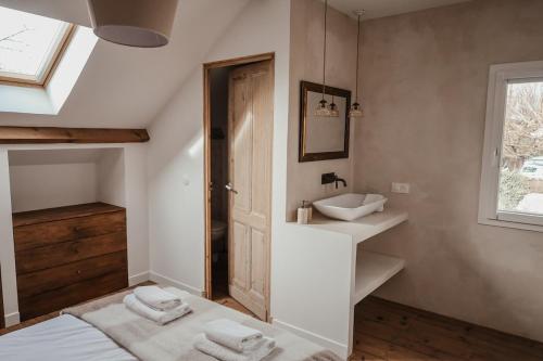 ein Badezimmer mit einem Bett, einem Waschbecken und einem Spiegel in der Unterkunft Maison en bord de Dordogne in Bergerac
