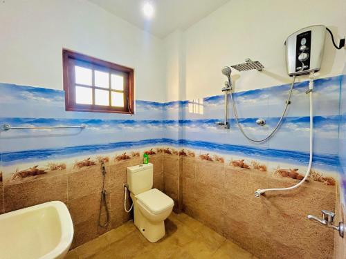 a bathroom with a shower and a toilet and a sink at Serene Stay - Cozy Upstairs Apartment in Waskaduwa