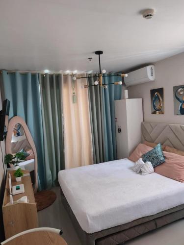 a bedroom with a large bed in a room at Cozy Studio with Balcony and Pool View in Lapu Lapu City