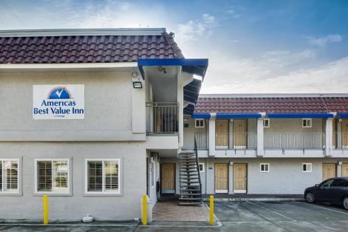 a building with a car parked in a parking lot at Americas Best Value Inn Richmond in Richmond