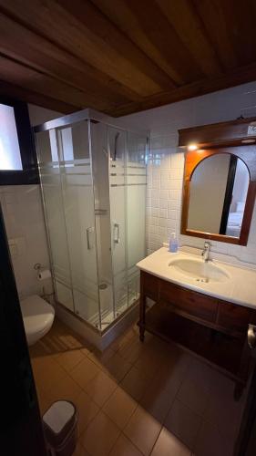a bathroom with a shower and a sink and a mirror at Akay Hotel in Selcuk