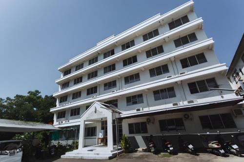 a white building with motorcycles parked in front of it at XX GO INN MAYA Chiang Mai - เมญ่า 2 in Chiang Mai