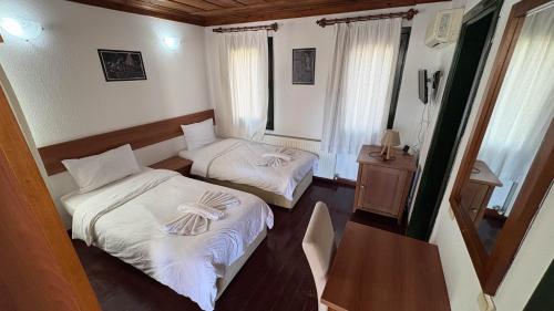 a small room with two beds and a table at Akay Hotel in Selcuk