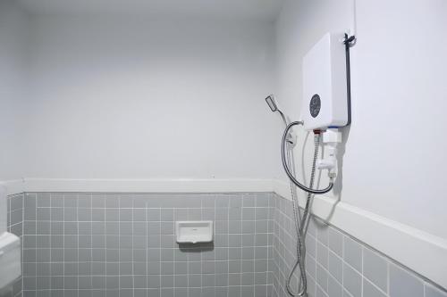 a shower in a bathroom with gray tiles at XX GO INN MAYA Chiang Mai - เมญ่า 2 in Chiang Mai