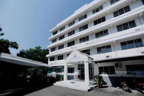 a large white building with a white entrance at XX GO INN MAYA Chiang Mai - เมญ่า 2 in Chiang Mai