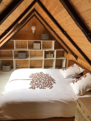 a bedroom with a white bed in a attic at Petite maison du causse in Salles-la-Source