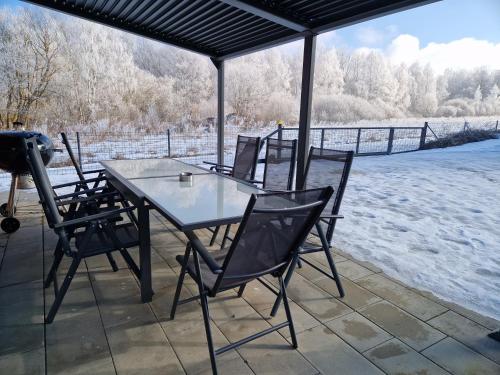 a table and chairs on a porch in the snow at Relax Vila Lipno 2 u pláže Windy Point in Černá v Pošumaví