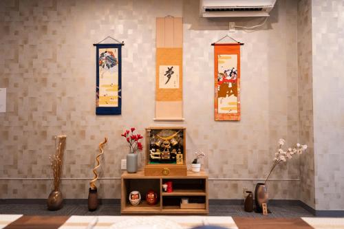 a room with vases and paintings on the wall at 福楽亭 in Minami-sotoborichō