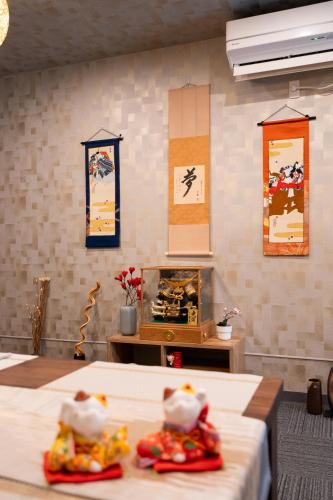 a room with two beds and paintings on the wall at 福楽亭 in Minami-sotoborichō