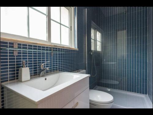 ポルシェスにあるVilla Vilamarの青いタイル張りのバスルーム(洗面台、トイレ付)