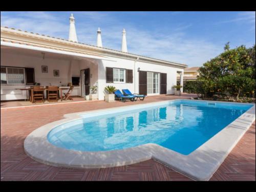 a swimming pool in front of a house at Villa Vilamar in Porches