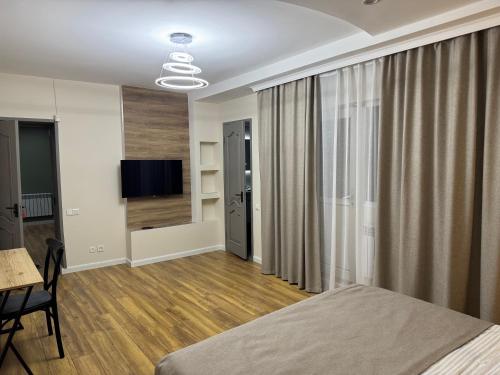 a bedroom with a bed and a table and a television at Ricco guest house in Bishkek