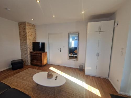 a living room with a white table and a tv at Ferienwohnungen Dümmersee - Haus Dümmerland - Wohnung 5 in Hüde