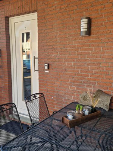 a table with two chairs and a brick wall at Ferienwohnungen Dümmersee - Haus Dümmerland - Wohnung 5 in Hüde