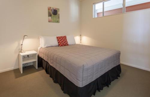A bed or beds in a room at Beachside Resort Motel Whitianga