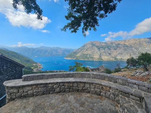 a stone wall with a view of a lake at Rector's house in Donji Stoliv