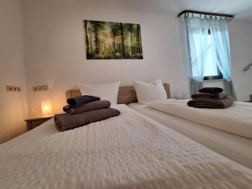 two beds in a room with towels on them at Hotel | Restaurant | Forellenzucht in Burgen