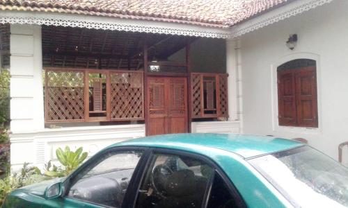 un coche verde estacionado frente a una casa en Southern Colonial Villa, en Matara