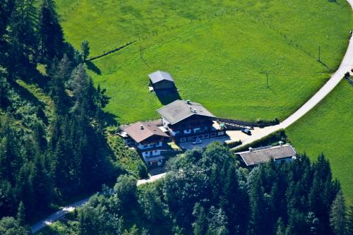 a large house in the middle of a green field at Bergwald Appartements Alpbach in Alpbach