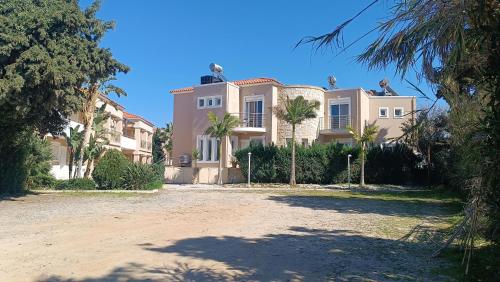 a large house with palm trees in front of it at Relax Private Pool House in Maleme