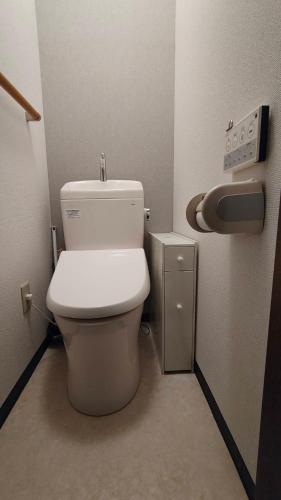 a bathroom with a toilet and a paper dispenser at エアポートマジカ in Toyonaka