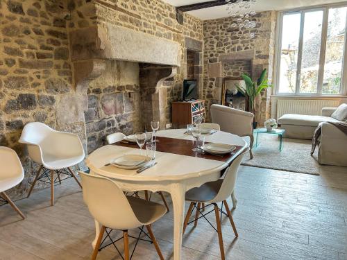 une salle à manger avec une table et des chaises et un mur en pierre dans l'établissement Le Havre de Pierre au bord de Rance, à Lanvallay