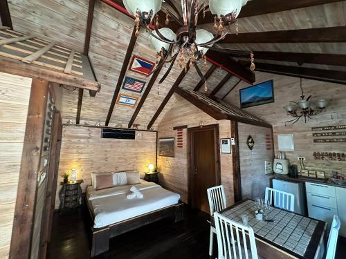 a bedroom with a bed and a table with chairs at בורקאי - בקתות פיליפיניות עם בריכה פרטית in Bruchim Qela' Alon