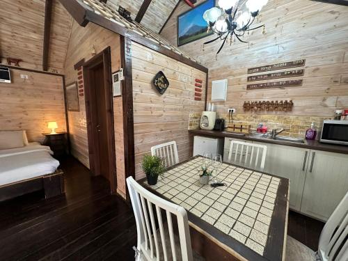 a room with a table and chairs and a bed at בורקאי - בקתות פיליפיניות עם בריכה פרטית in Bruchim Qela' Alon