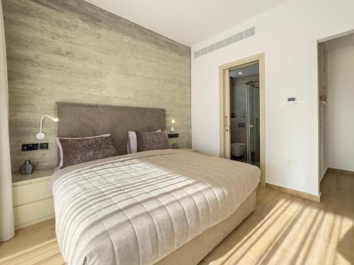 a bedroom with a large bed with a wooden floor at Malberry Park 102 - Modern Apt with Shared Heated Pool, Sauna, Gym, Jacuzzi in Paphos City