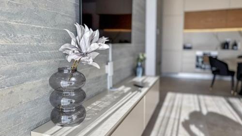 a vase with flowers in it sitting on a counter at Malberry Park 102 - Modern Apt with Shared Heated Pool, Sauna, Gym, Jacuzzi in Paphos City