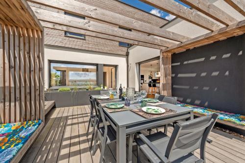 une salle à manger avec une table et des chaises sur une terrasse dans l'établissement Villa vue mer, plage à 30 metres, à Le Relecq-Kerhuon