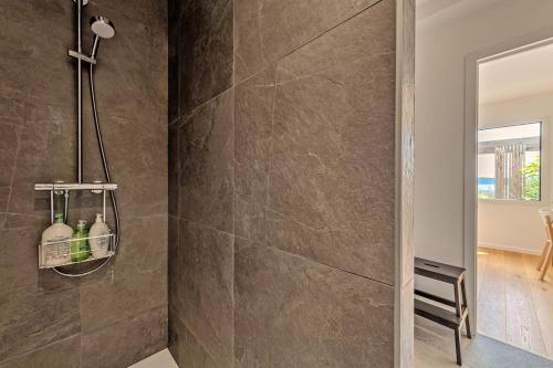 La salle de bains est pourvue d'un mur en pierre et d'une douche. dans l'établissement Villa vue mer, plage à 30 metres, à Le Relecq-Kerhuon