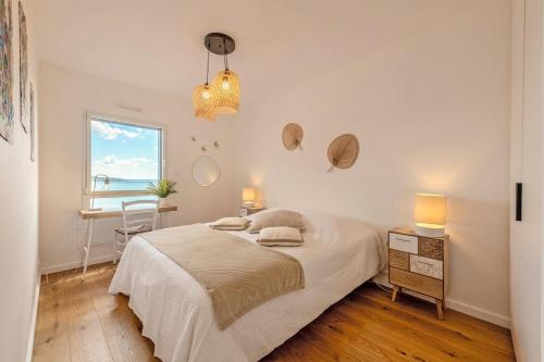 une chambre blanche avec un lit et une fenêtre dans l'établissement Villa vue mer, plage à 30 metres, à Le Relecq-Kerhuon