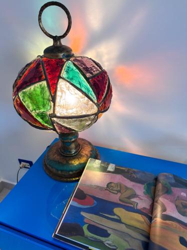 a stained glass lamp sitting on a table next to a book at Casa Iside in Ladispoli