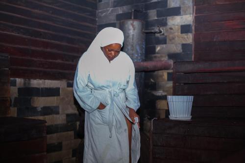 a man in a white robe standing in a room at Nefaland Hotel in Dar es Salaam