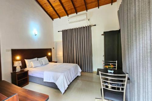 a bedroom with a bed and a desk and a chair at Niwahana Holiday Resort in Polonnaruwa