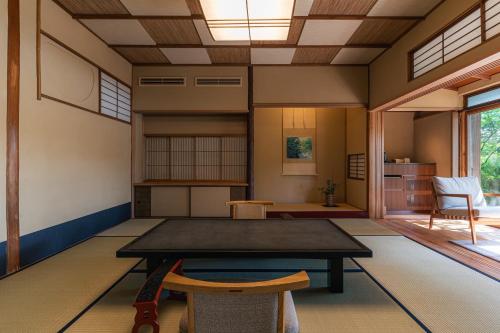 a room with a table and chairs in it at Monjusou Shourotei in Miyazu