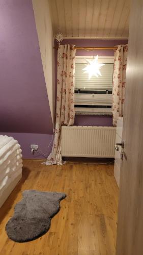 an attic room with a window with a star in the curtain at Biggy's Apartment in Selb