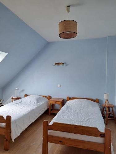 - 2 lits dans une chambre avec un mur bleu dans l'établissement Maison familiale avec jardin de 300m2, au Croisic