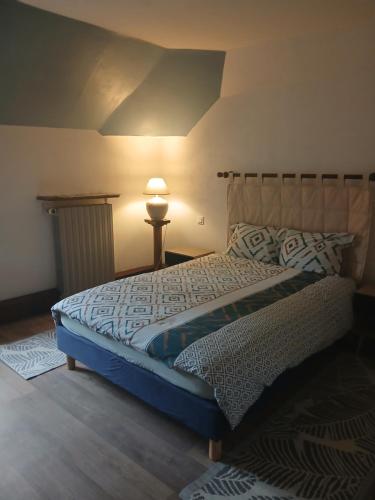 a bedroom with a bed with a lamp and a bed sidx sidx sidx at La Bergeronnette Le Buisson in La Chapelle-Saint-André