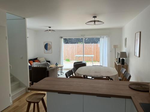 une cuisine et un salon avec une table et des chaises dans l'établissement Villa neuve 300 m plage sud 3 chambres, à Lacanau